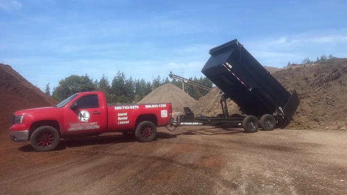 Northwest Landscaping & Hardscaping's truck and dump trailer at a materials yard