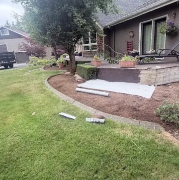 Fresh bark mulch bed and stone edging along a front lawn